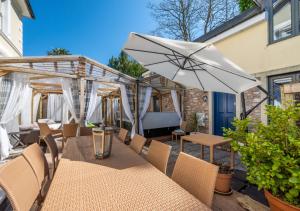 a patio with a table and an umbrella at Rutland Lodge Wellswood Mews in Torquay