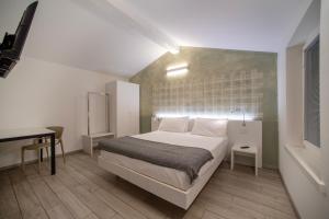 CityU - Grazioli 27 Trento Centro con parcheggio privato في ترينتو: غرفة نوم فيها سرير ومكتب