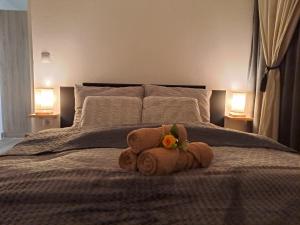 a teddy bear laying on a bed with two lamps at Gottscheelux in Kočevje
