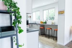 a kitchen with white counters and orange stools at La Villa Capuccine in Nîmes +26 photos