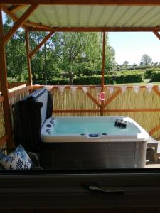 eine Badewanne auf einer abgeschirmten Veranda in der Unterkunft Lakes and Eden Valley. Thornhill Cabin in Long Marton