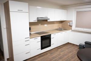 a kitchen with white cabinets and a sink at Gottscheelux in Kočevje