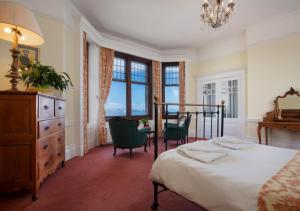 a bedroom with a bed and a table and chairs at Wolborough House in Brixham