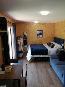 ein Schlafzimmer mit einem Bett und einem Sofa in der Unterkunft Lakes and Eden Valley. Thornhill Cabin in Long Marton