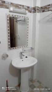 a bathroom with a white sink and a mirror at Chez Mamanta Studio meublé à St louis in Saint-Louis