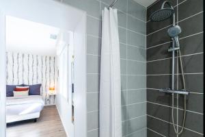 a bathroom with a shower and a bed in a room at La Villa Capuccine in Nîmes
