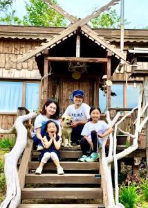 una familia sentada en una casa de juegos con un perro en Tezukuri Cottage Mauranarani - Vacation STAY 49824v en Shimatokkari