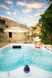 a woman is sitting in a jacuzzi tub at Cappadocia Splendid Cave Hotel in Ortahisar