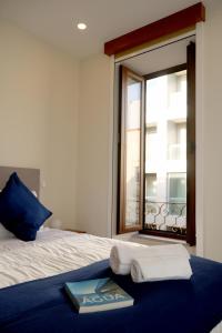 een slaapkamer met een bed met handdoeken en een raam bij Cabo do Mar Apart- Azul Beach in Espinho
