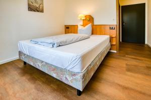 a large white bed in a room with wooden floors at Guesthouse Beckmann in Göttingen