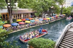 a group of people riding on a boat down a river at SpringHill Suites by Marriott San Antonio Airport in San Antonio