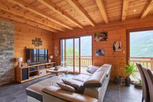 a living room with a couch and a television at chalet la traverse in Allemont