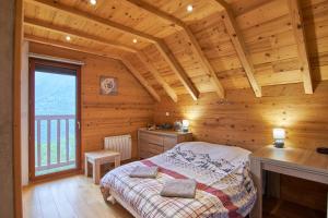 a bedroom with a bed in a wooden house at chalet la traverse in Allemont
