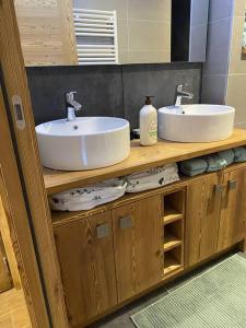 a bathroom with two sinks on a wooden counter at LE DOUX MELEZE in Saint-Chaffrey