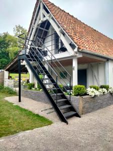 un escalier en colimaçon devant une maison dans l'établissement Le grenier de Mamou, à Hesdigneul-lès-Boulogne
