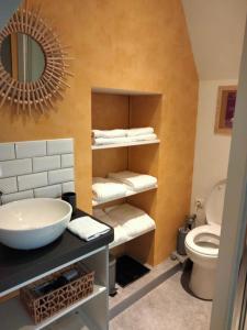 a bathroom with a sink and a toilet and a mirror at Le grenier de Mamou in Hesdigneul-lès-Boulogne