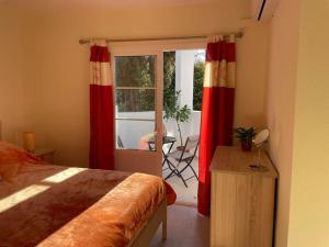 Schlafzimmer mit roten Vorhängen und einem Tisch mit Stuhl in der Unterkunft Casa Sally - Mijas Golf in Mijas Costa