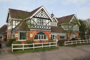 St George's Lodge, Bisley في Brookwood: منزل امامه سياج ابيض