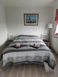 Un dormitorio con una cama con una manta. en The red house near the sea, en Njarðvík