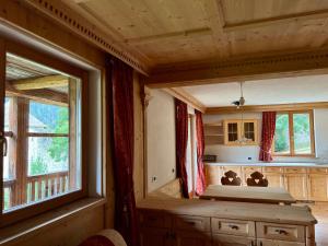 um quarto com uma cama e uma grande janela em Luxury Chalet at the Foot of the Dolomites by the Castle em La Villa
