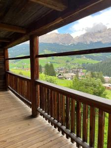 a wooden balcony with a view of mountains at Luxury Chalet at the Foot of the Dolomites by the Castle in La Villa