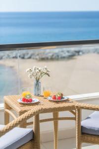 une table avec deux assiettes de fruits et de jus d'orange dans l'établissement Hotel Rosamar, à Sant Antoni de Calonge