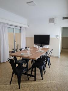 a large wooden table with chairs and a flat screen tv at BELGRANO HOME. ALQUILER TEMPORARIO EN SAN FRANCISCO in San Francisco