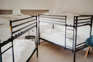 a room with three bunk beds with white sheets at Luxurious 4BR Villa's In Knokke in Knokke-Heist