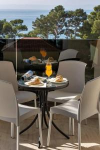 a table and chairs with food and drinks on a balcony at Apartment Hrvoje -nur 50m bis zum Meer - Makarska Exklusiv in Promajna