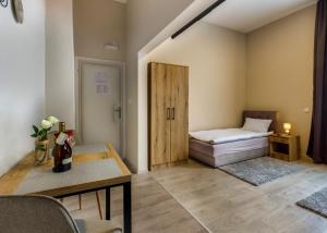 pokój z łóżkiem i stołem oraz pokój z drzwiami w obiekcie Vila Bor apartmani w mieście Bečej