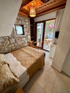 a bedroom with a bed and a stone wall at Koparan Apart Hotel in Akyaka