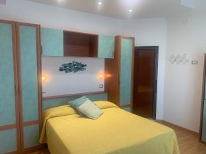 een slaapkamer met een geel bed in een kamer bij Hotel Atlantic in Bellaria-Igea Marina