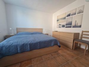 a bedroom with a bed and a chair and pictures on the wall at Apartmány Modrý deň in Bojnice