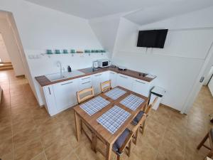 uma cozinha com uma mesa e cadeiras e um lavatório em Apartmány Modrý deň em Bojnice