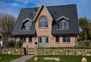 a brick house with a gambrel roof at Strand und Meer in List