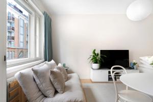 sala de estar blanca con sofá blanco y ventana en Stylish Nordic Studio by Tram Stop, en Helsinki