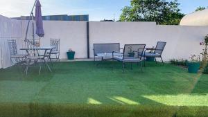 patio ze stołem i krzesłami na trawie w obiekcie La coulée verte w mieście Auxerre