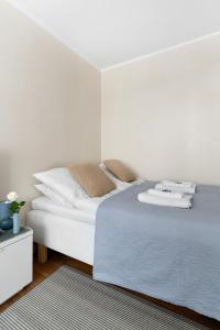 a bedroom with a bed with white sheets and pillows at Stylish Nordic Studio by Tram Stop in Helsinki