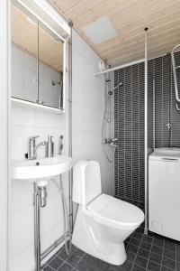 a bathroom with a toilet and a sink and a shower at Stylish Nordic Studio by Tram Stop in Helsinki
