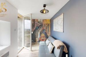 un salon bleu avec un canapé et une fenêtre dans l'établissement La Source d'Eugénie Vue Panoramique au Bugue, au Bugue