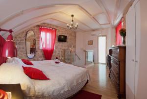 a bedroom with a large bed with red pillows at Bed & Breakfast Vila Baguc in Split