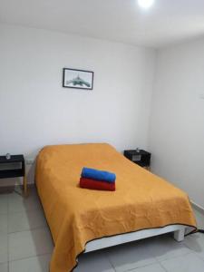 Una cama con dos almohadas rojas y azules. en Home dream, en Querétaro