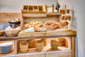 a bakery with baskets of bread and pastries on a shelf at Hotel Beckmann in Göttingen