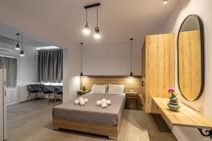 sypialnia z łóżkiem, stołem i lustrem w obiekcie Katerina View w mieście Mykonos