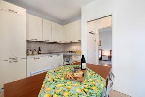 een keuken met een tafel en een fles wijn bij Katy Lake 1 in Desenzano del Garda