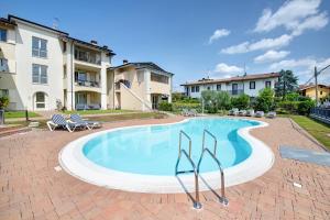 een groot zwembad met stoelen en een gebouw bij Katy Lake 1 in Desenzano del Garda