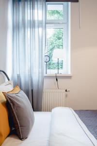 - une chambre avec un lit doté d'une fenêtre et d'un oreiller dans l'établissement Apartamenty Pamiątkowa 11, 2 rooms, self check in 24h, à Poznań
