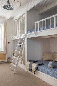 a bedroom with two bunk beds and a ladder at Agapella Apartamenty- Sopot Cottage Ogród 400m od plaży 6 dorosłych i dzieci in Sopot