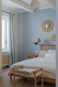 1 dormitorio con paredes azules y 1 cama con banco en Agapella Apartamenty- Sopot Cottage Ogród 400m od plaży 6 dorosłych i dzieci en Sopot