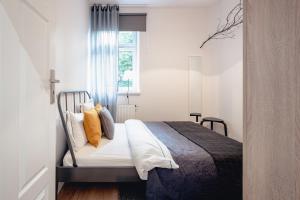 - une chambre avec un lit doté d'oreillers jaunes et d'une fenêtre dans l'établissement Apartamenty Pamiątkowa 11, 2 rooms, self check in 24h, à Poznań